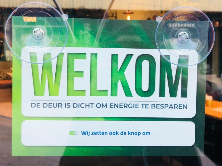 Winkels Almere Centrum voorzien van bordjes om deur dicht te laten om energie te besparen